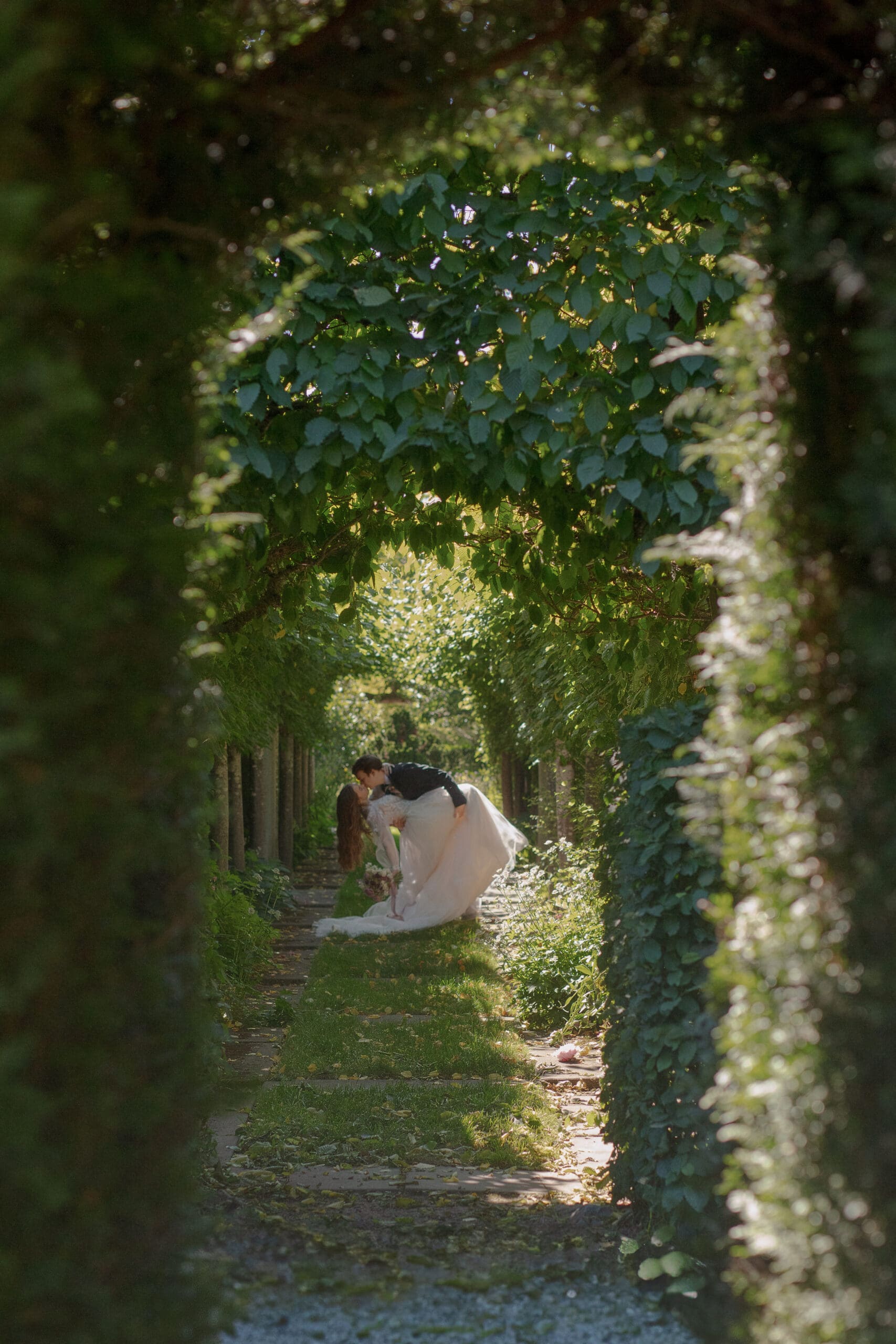 Bride and groom framed by greenery in a romantic garden arch at Briarwood Estate.