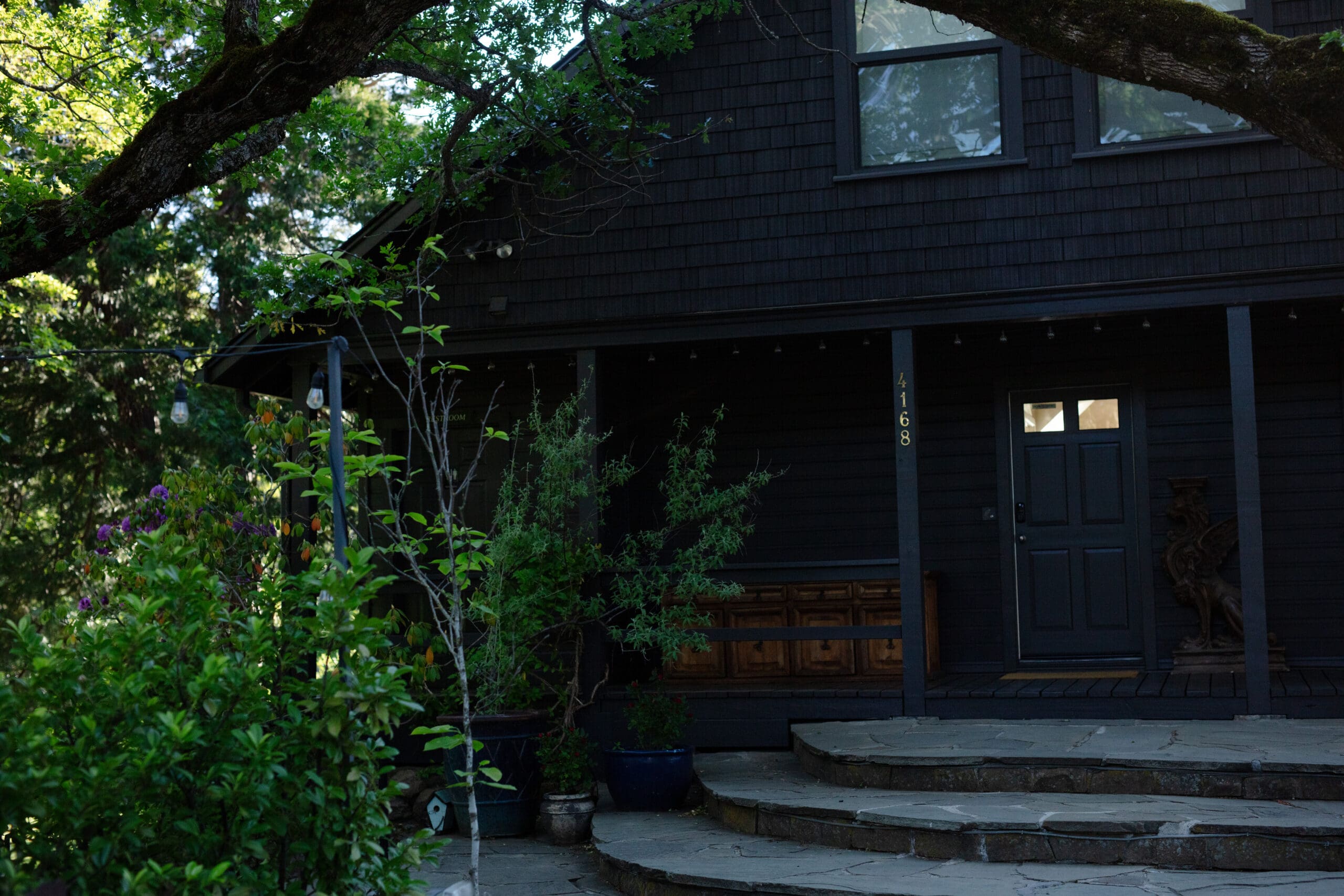 The front steps of The Griffin House surrounded by garden foliage and soft morning light before a wedding day.