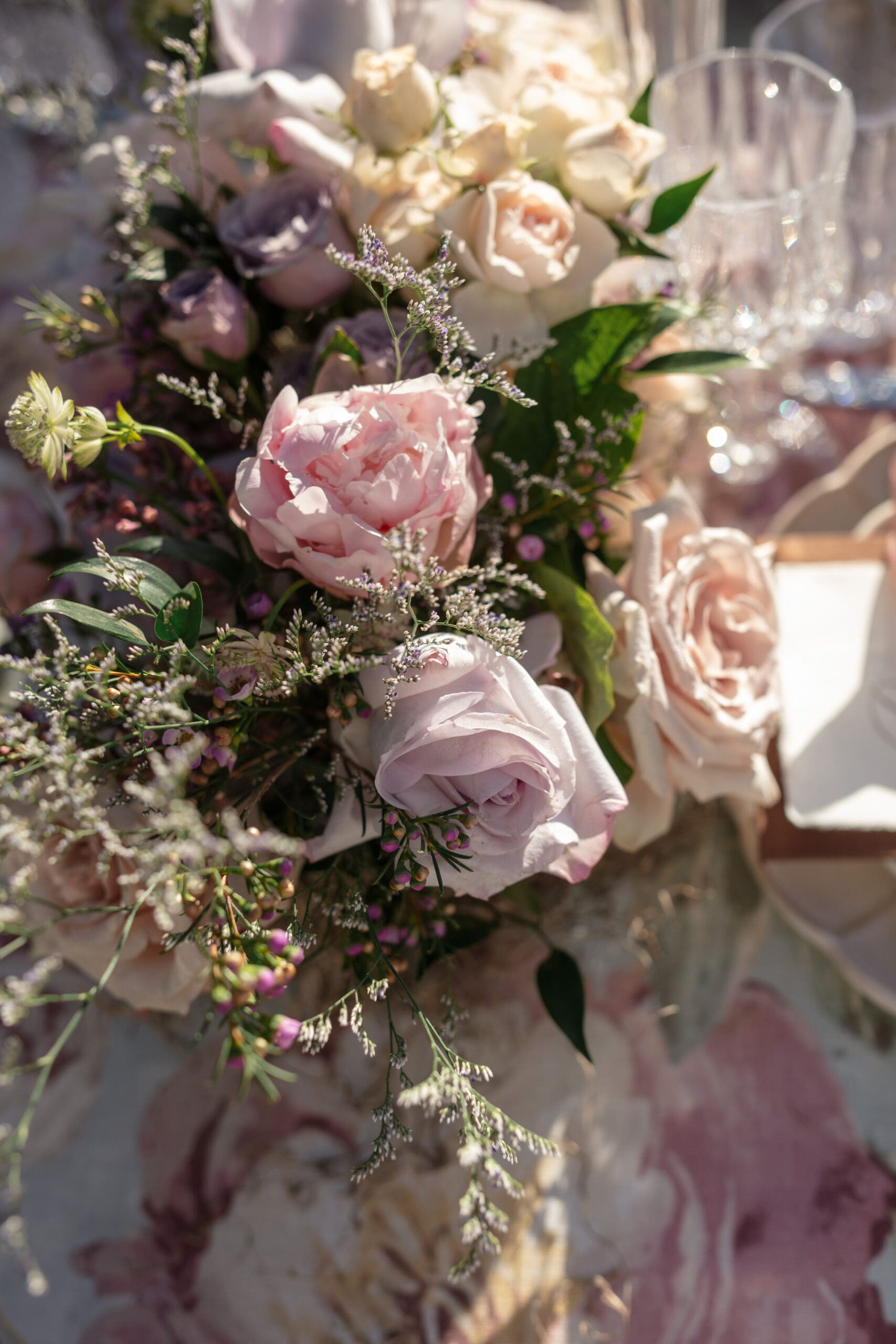 Floral centerpiece with blush and lavender roses in soft golden hour light, styled for The Griffin House wedding
