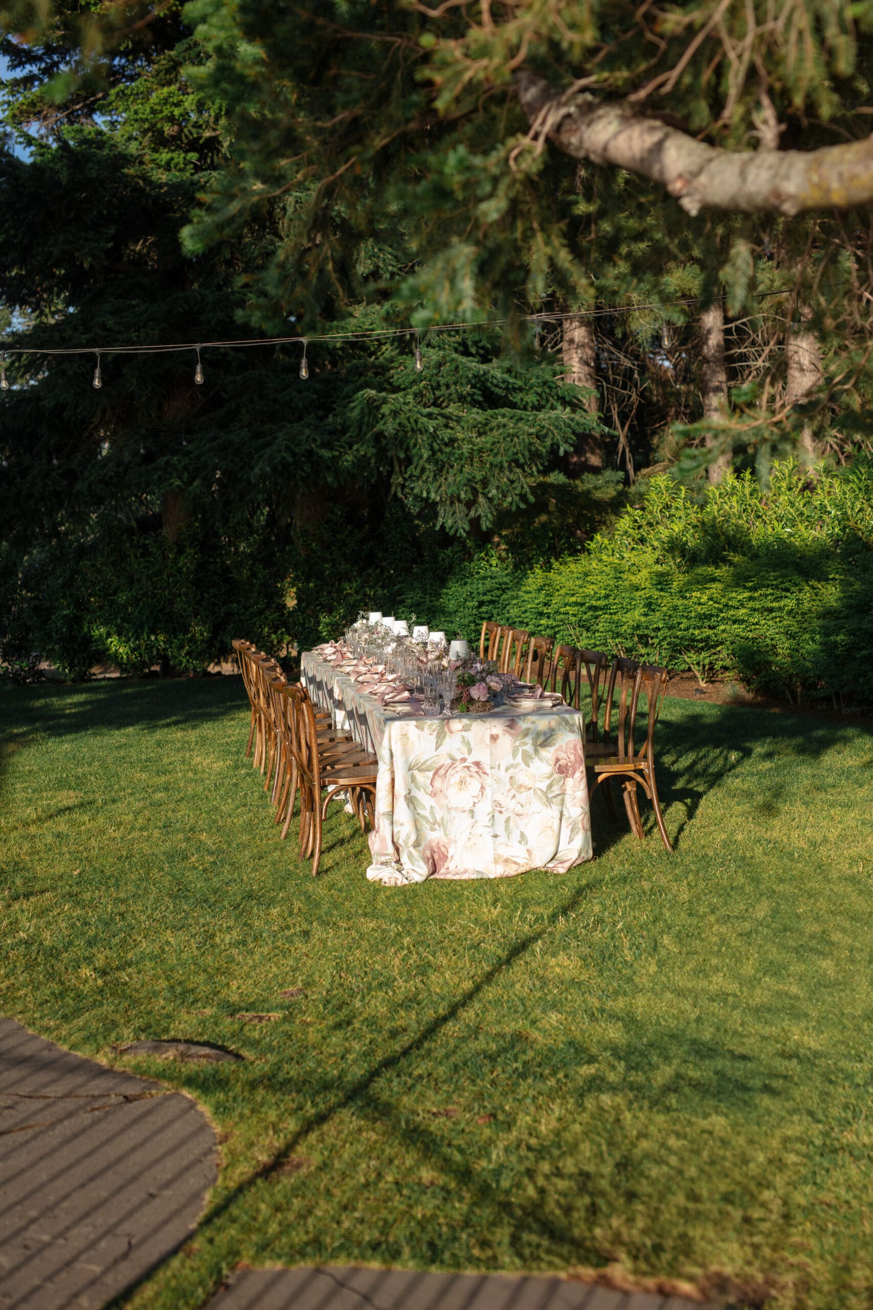 Outdoor reception table styled with floral linens and wooden chairs at The Griffin House wedding

