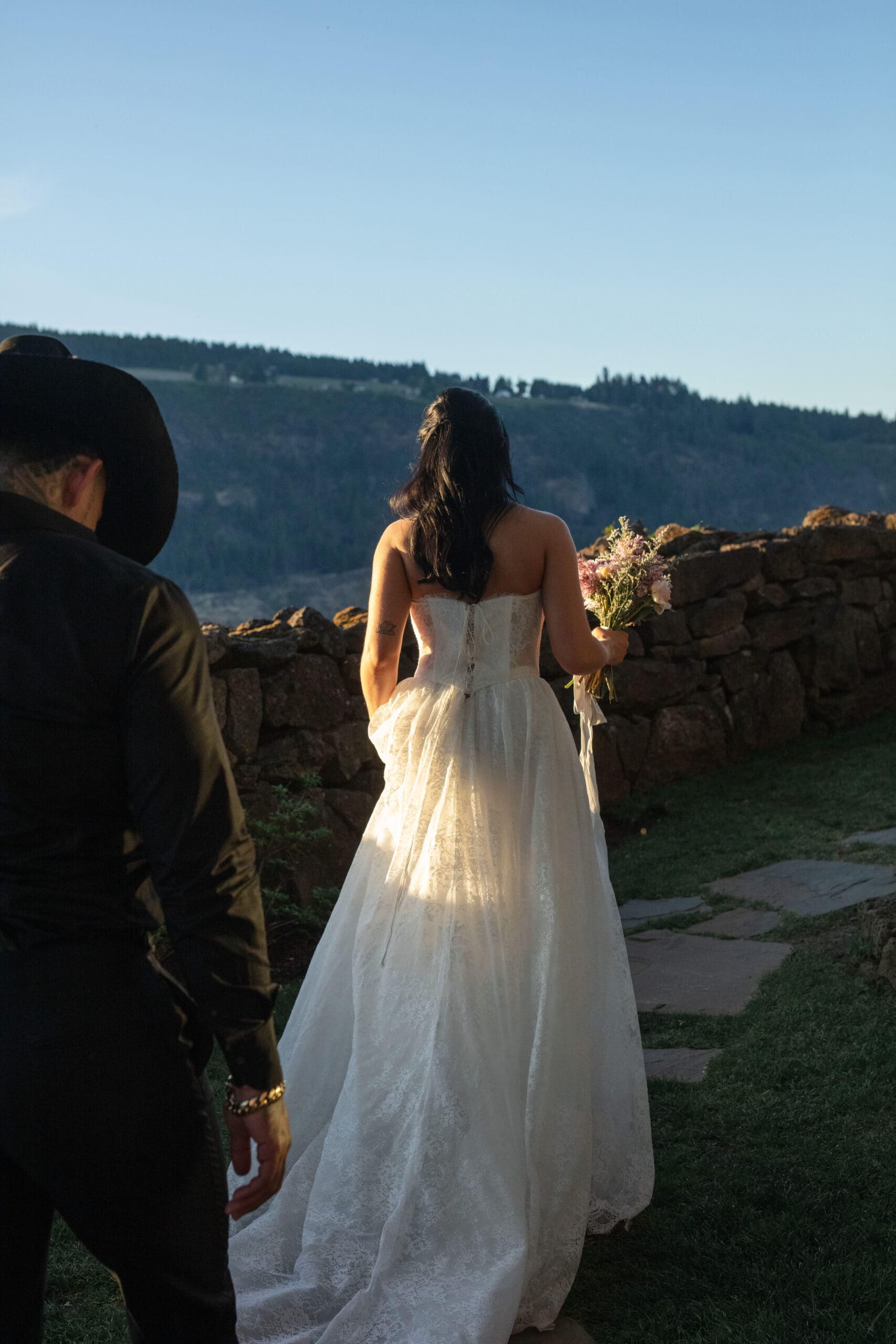 Bride walking toward the view at The Griffin House with golden light catching her gown