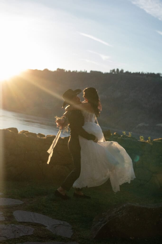 Romantic lift-and-spin moment between bride and groom at golden hour during a Griffin House wedding.