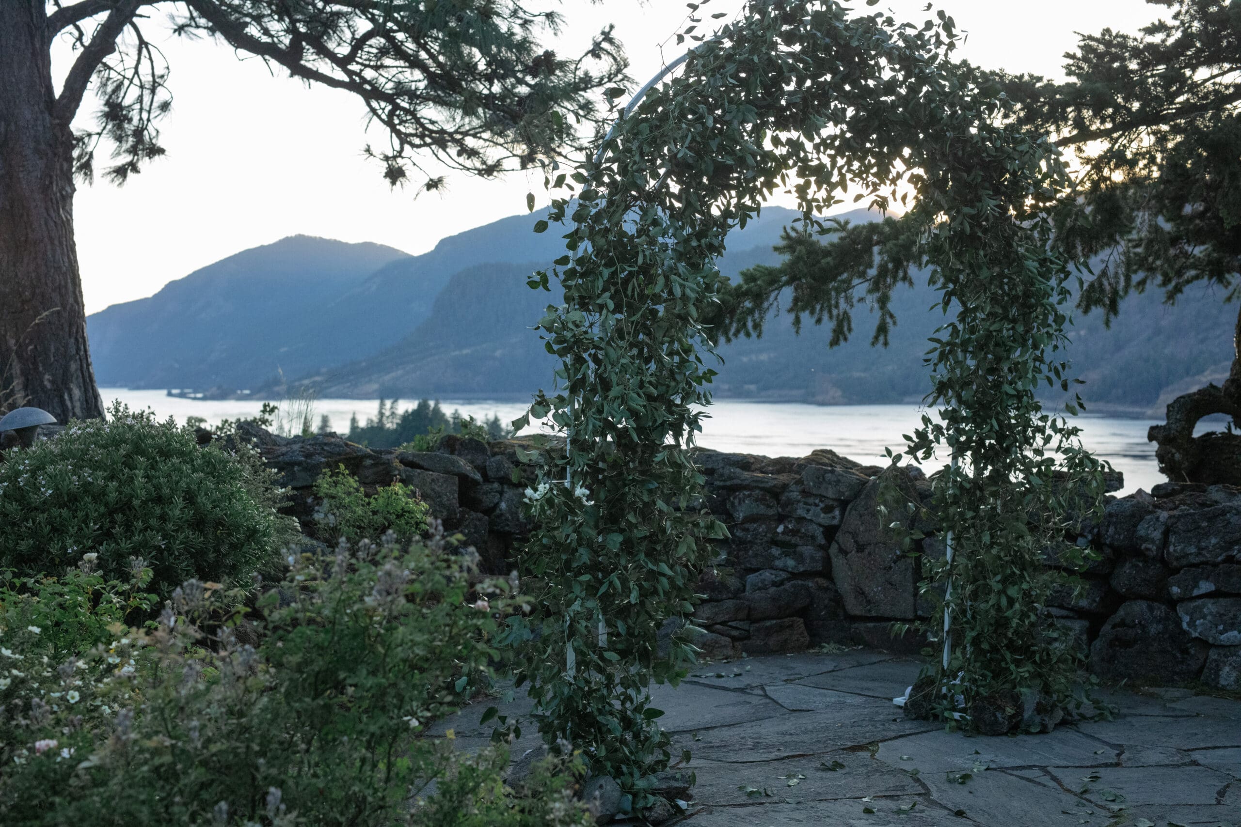 Lush greenery wedding arch set against the iconic Columbia River Gorge view at a Griffin House wedding ceremony site.