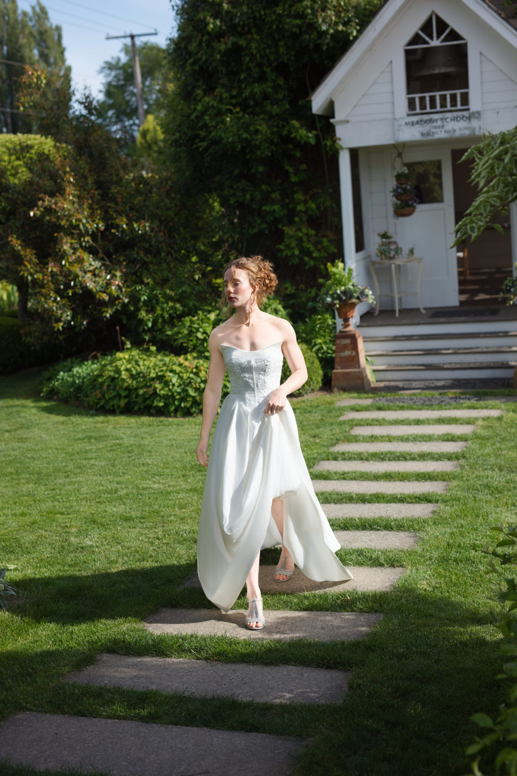 Bride walking barefoot across the stone path outside the cottage at this Washington wedding venue.
