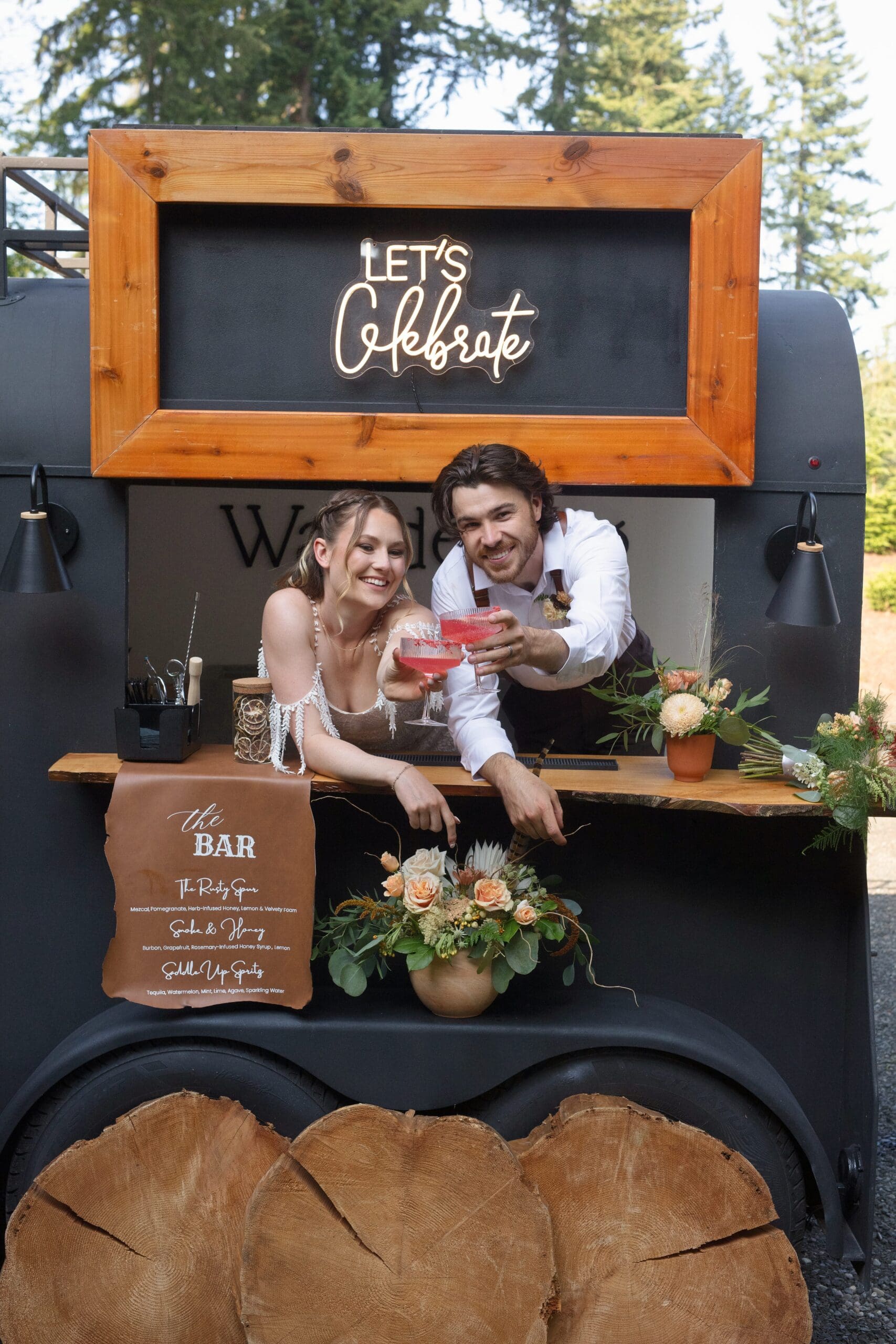 Couple serves signature cocktails from a wood-paneled bar cart – relaxed and guest-friendly beverage ideas for weddings.