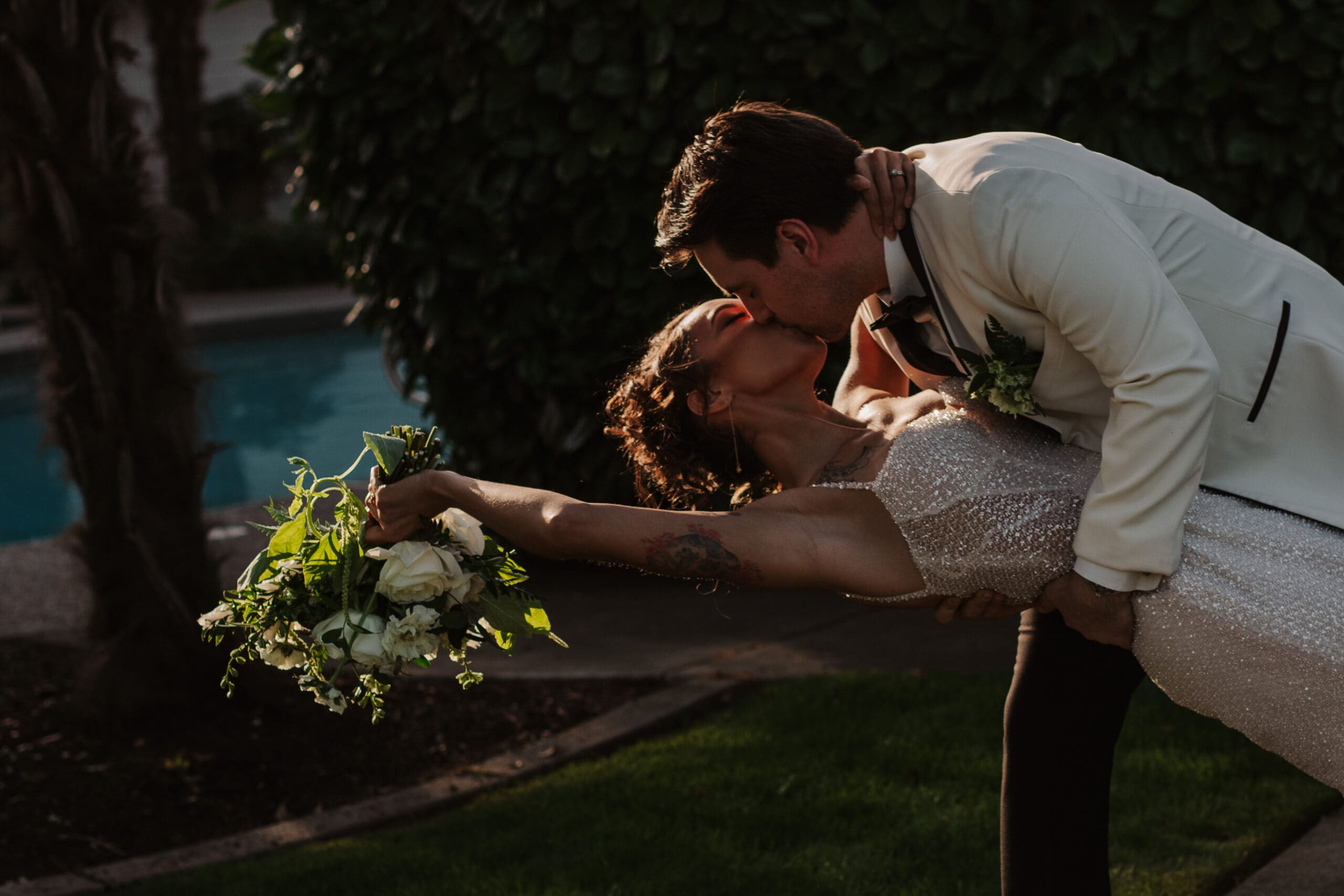 Sunset kiss beside the pool, capturing joyful spontaneity—natural and candid ideas for weddings full of connection.