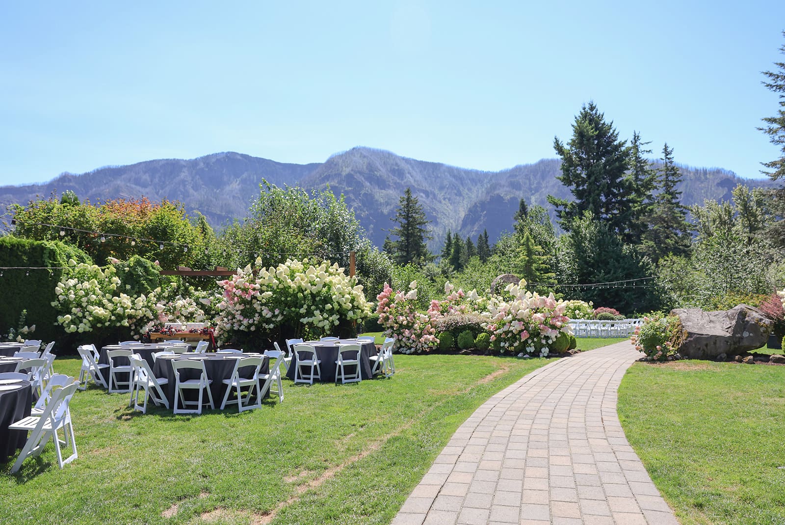 Cape Horn Estate reception lawn with floral gardens, mountain views, and guest tables set beneath the Columbia River Gorge.