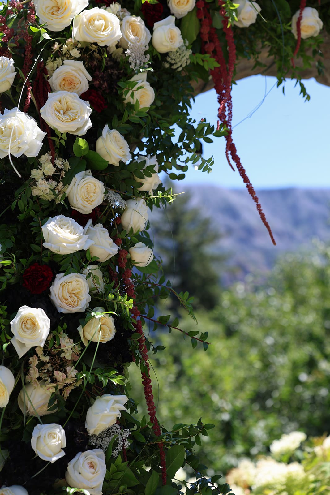 Elegant floral ceremony arch at Cape Horn Estate, blending white and red roses with sweeping views of the Gorge.