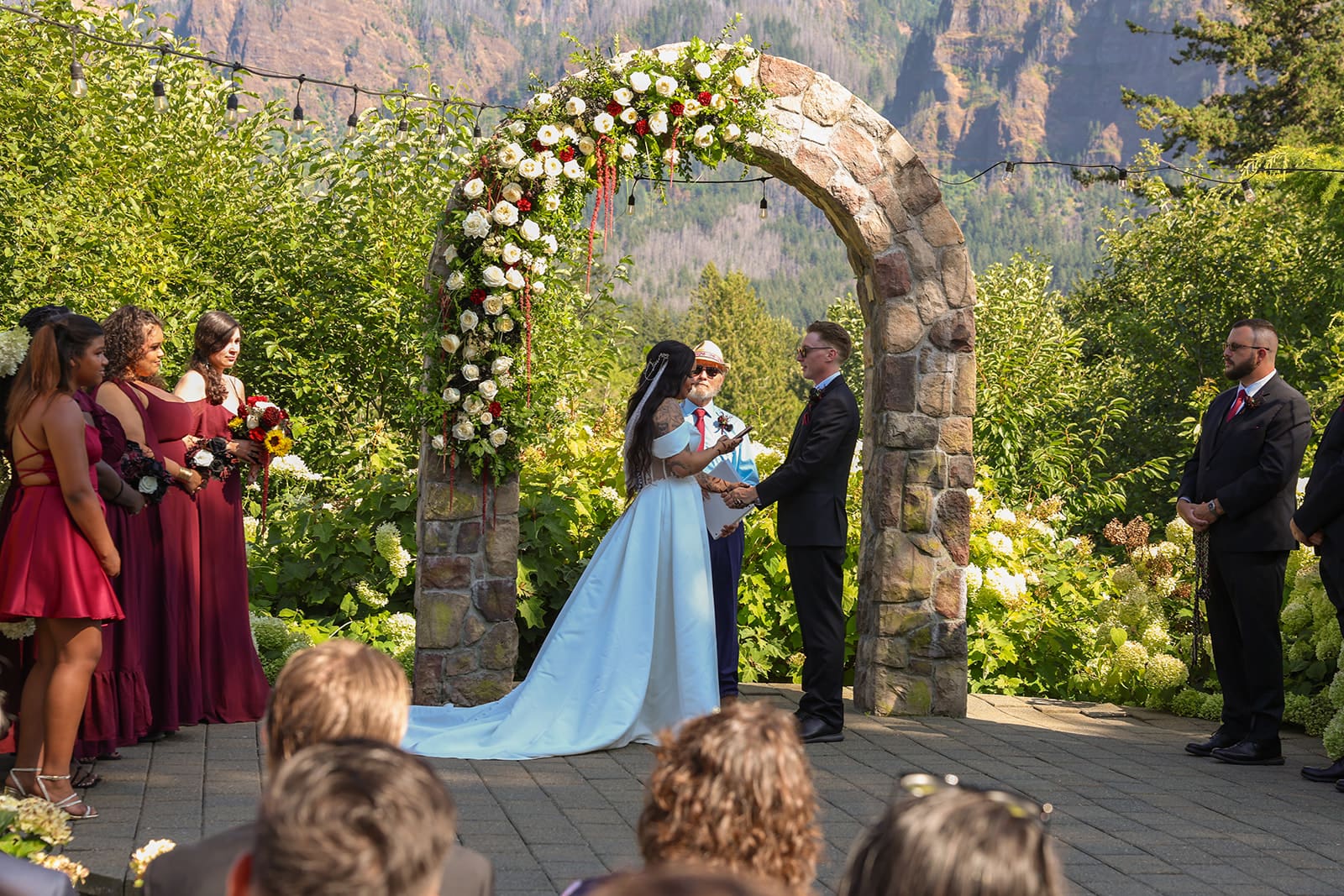 Bride and groom at outdoor wedding ceremony with stone alter behind them