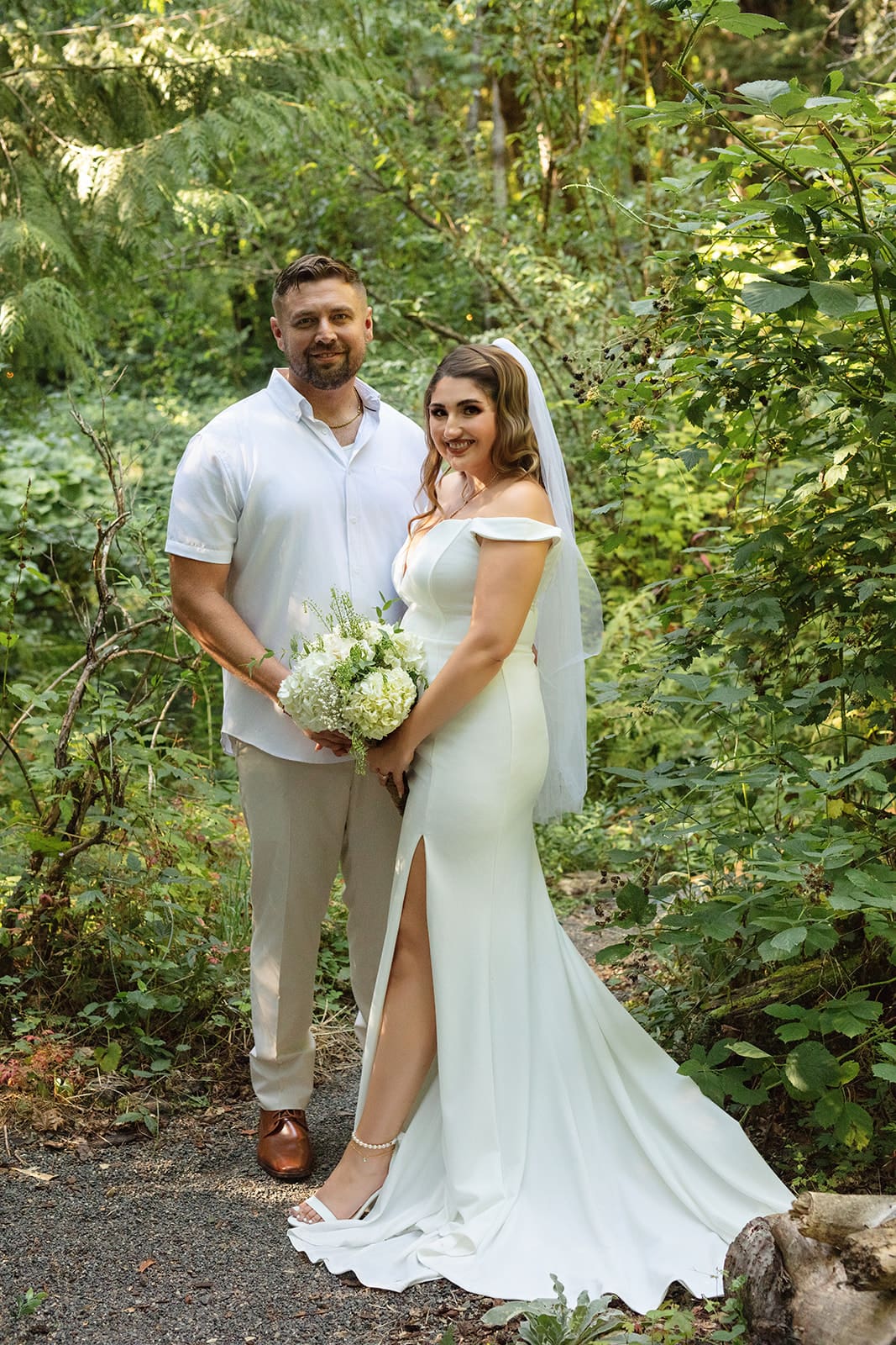 The newlyweds stand side by side in the woods, surrounded by lush greenery and soft afternoon light — airbnb weddings capture beauty in simplicity.