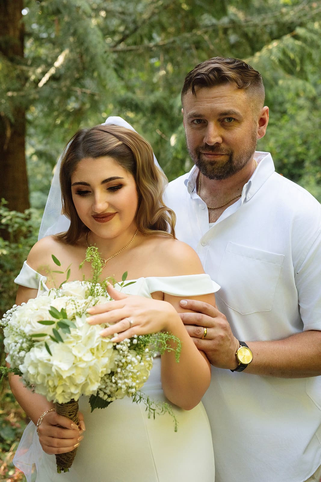 The couple shares a quiet, close-up moment in the woods, smiling softly at the camera — the heart of airbnb weddings.