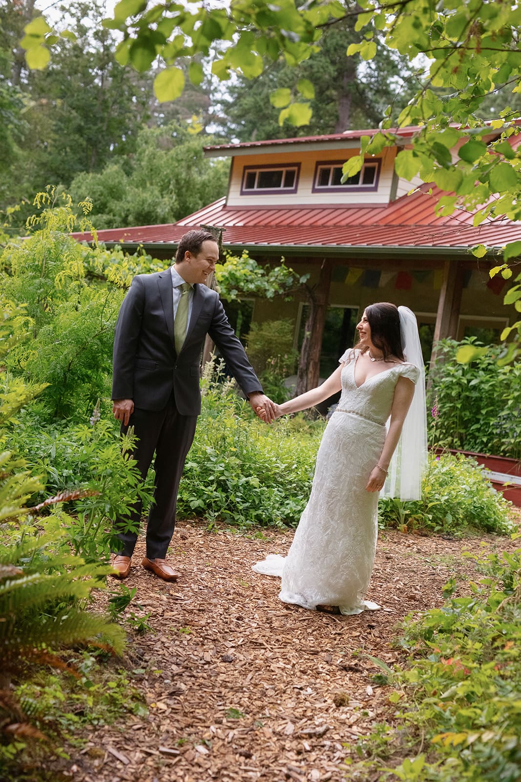 Couple walking through forested garden paths during their wedding in Washington state.