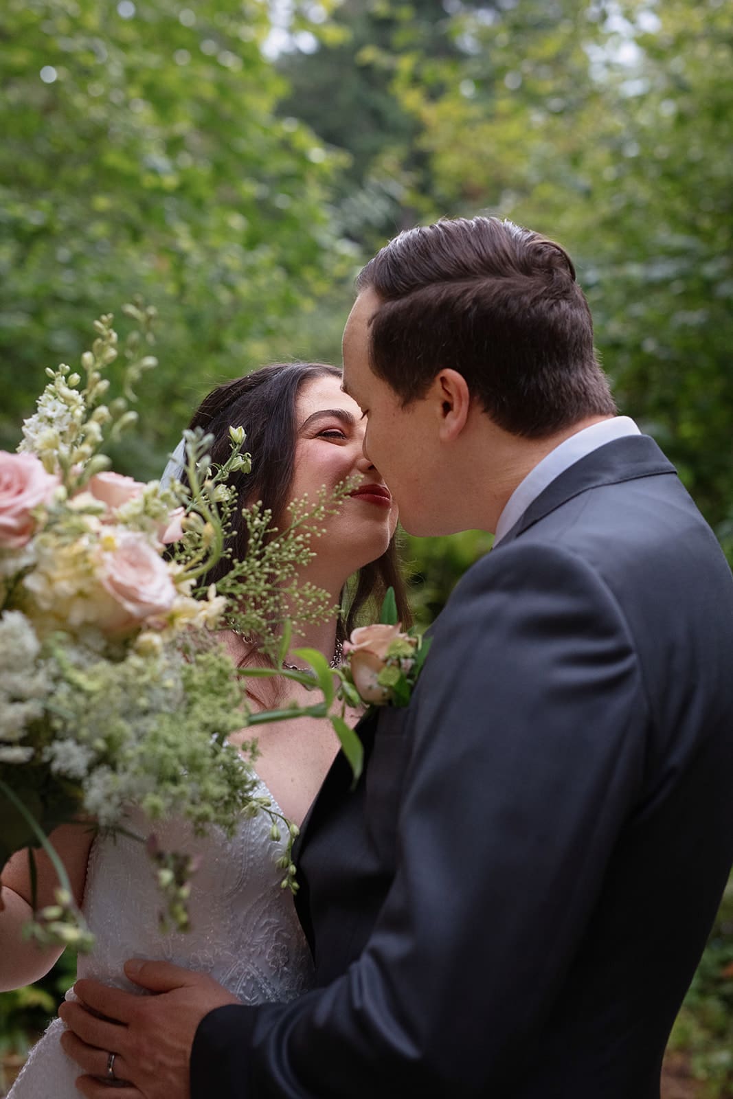 Newlyweds sharing a joyful, close moment in the woods after their wedding in Washington state.