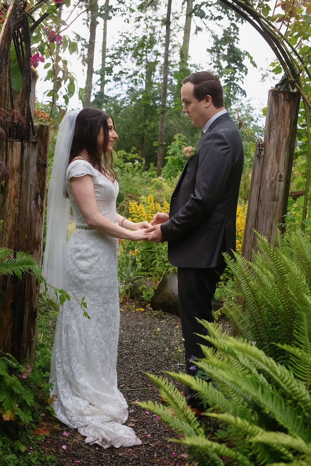 A heartfelt exchange of vows under the trees during an outdoor wedding in Washington state, surrounded by ferns and wildflowers.