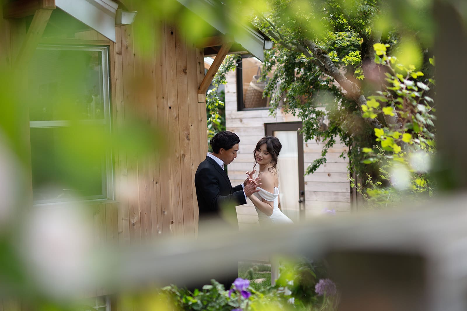 Bride and groom laughing together in the garden, soaking in the excitement of their wedding day.