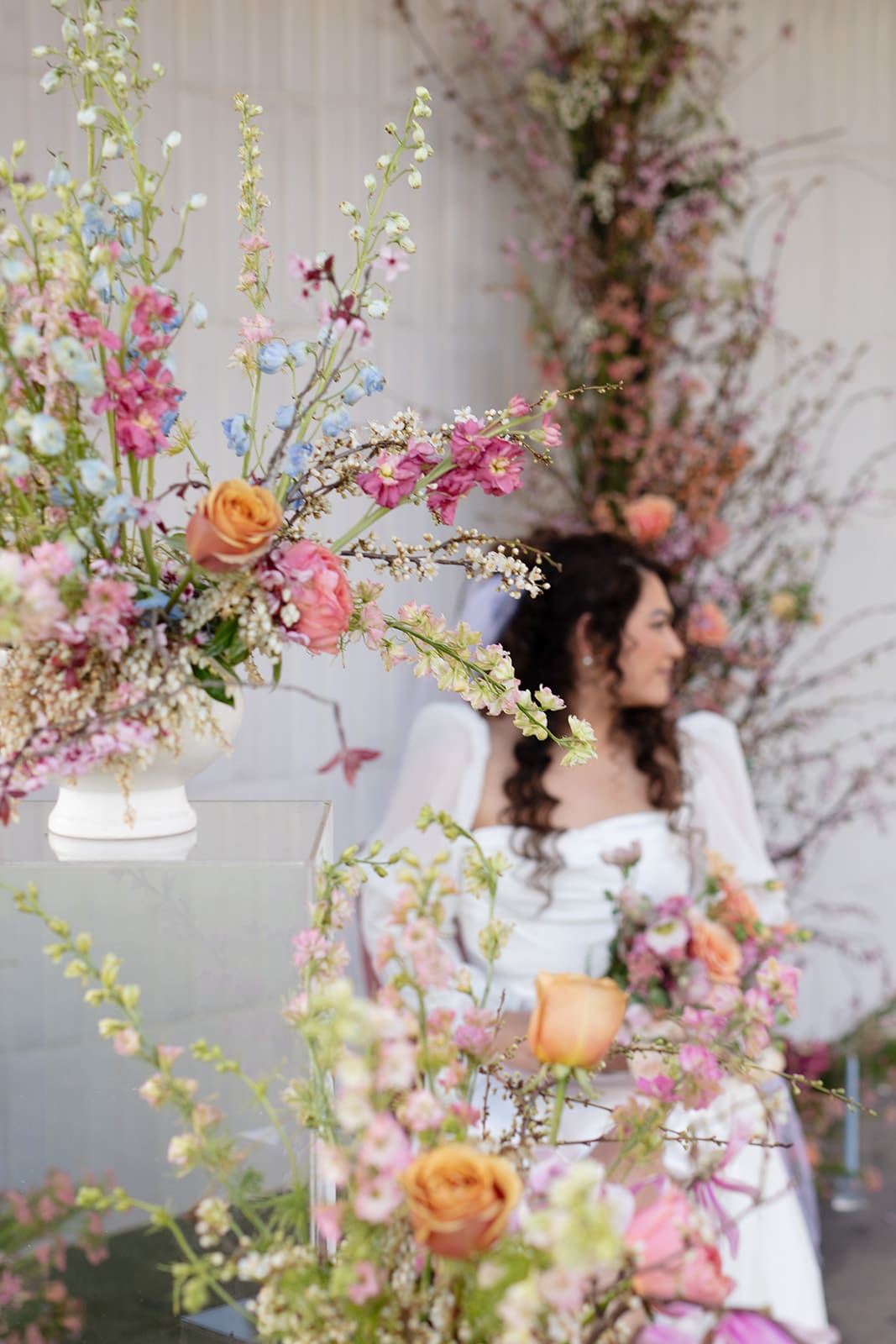 Bride surrounded by whimsical spring florals, captured during a romantic wedding session.